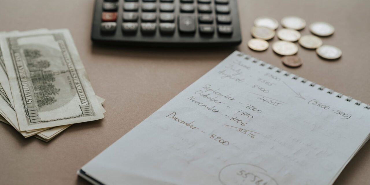 Bütçe planı için not defteri, hesap makinesi ve kalem